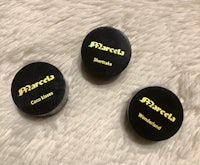 three black and gold buttons on a furry surface