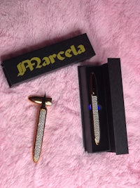 a gold pen and a pink box on top of a pink fur