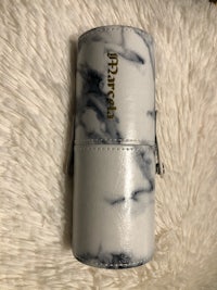 a white marble makeup case on a white fur rug