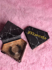 a pair of false eyelashes in a box on a pink fur