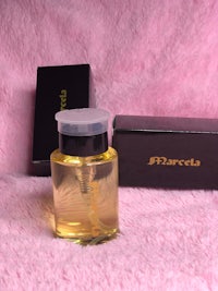 a bottle of perfume sitting on a pink blanket
