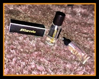 a bottle of perfume and a box on a carpet