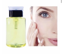 a woman's face with a bottle of facial oil