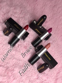 four lipsticks with the words warrior, brave, and faith