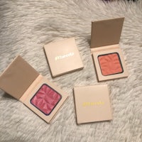 three blushes sitting on top of a fur rug