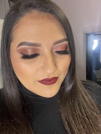 a woman with long brown hair and a burgundy lipstick