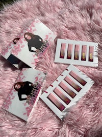 a set of pink lipsticks on a pink fur rug