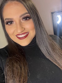 a woman wearing a black turtle neck top and lipstick