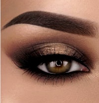 a close up of a woman's eye with brown and gold eye makeup