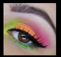 a close up of a woman's eye with colorful eye makeup